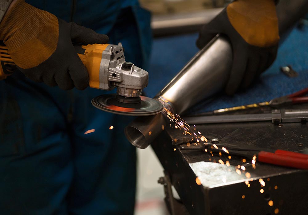 Technician worker cutting metal with many sharp sparks. Using equipments to cat iron